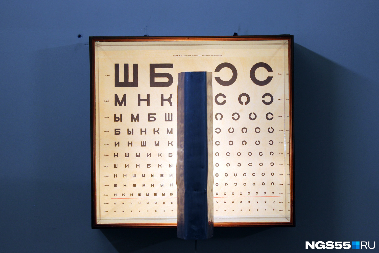 Таблица Сивцева для проверки остроты зрения. На подоконнике стоит электронный прибор — альтернатива устаревшей таблице, но офтальмологи пользуются и тем и другим