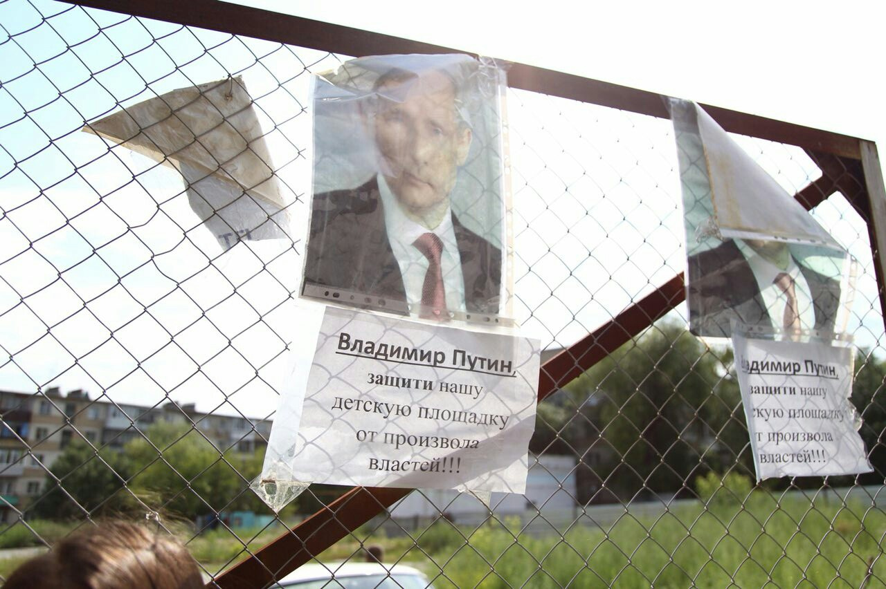 О помощи жители домов просят президента России, его фотографии расклеены по всему периметру