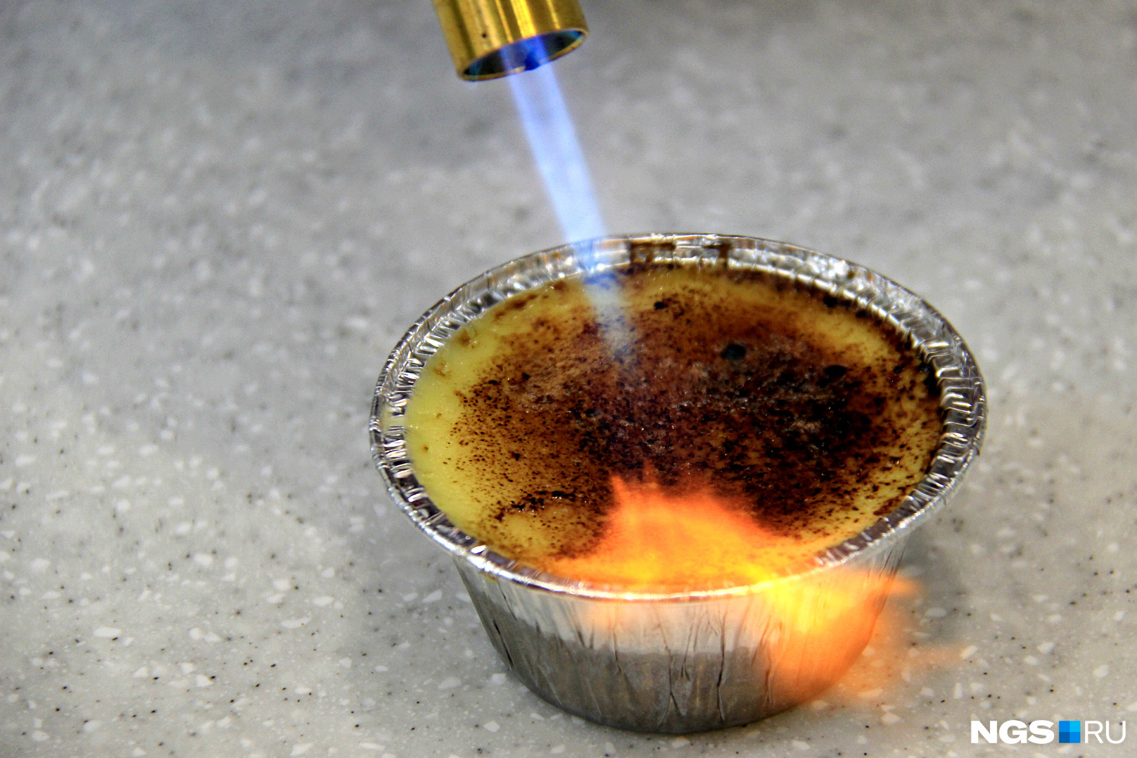 Процесс приготовления крем-брюле с помощью газовой горелки