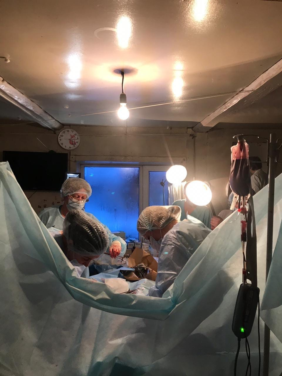 С лампой в руках, но не в операционной, а посреди обычной комнаты — в таких условиях пришлось работать врачам