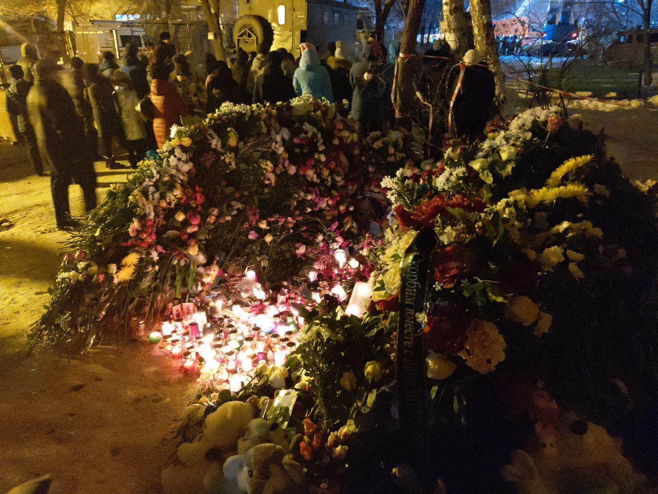 Жители несут к дому охапки цветов Жители несут к дому охапки цветов