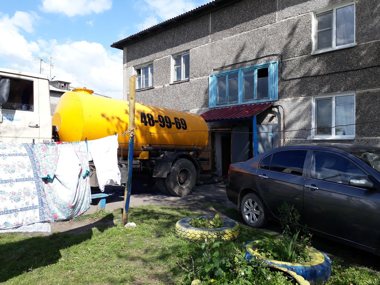 Ассенизаторская машина откачивает нечистоты из подвала дома Ассенизаторская машина откачивает нечистоты из подвала дома