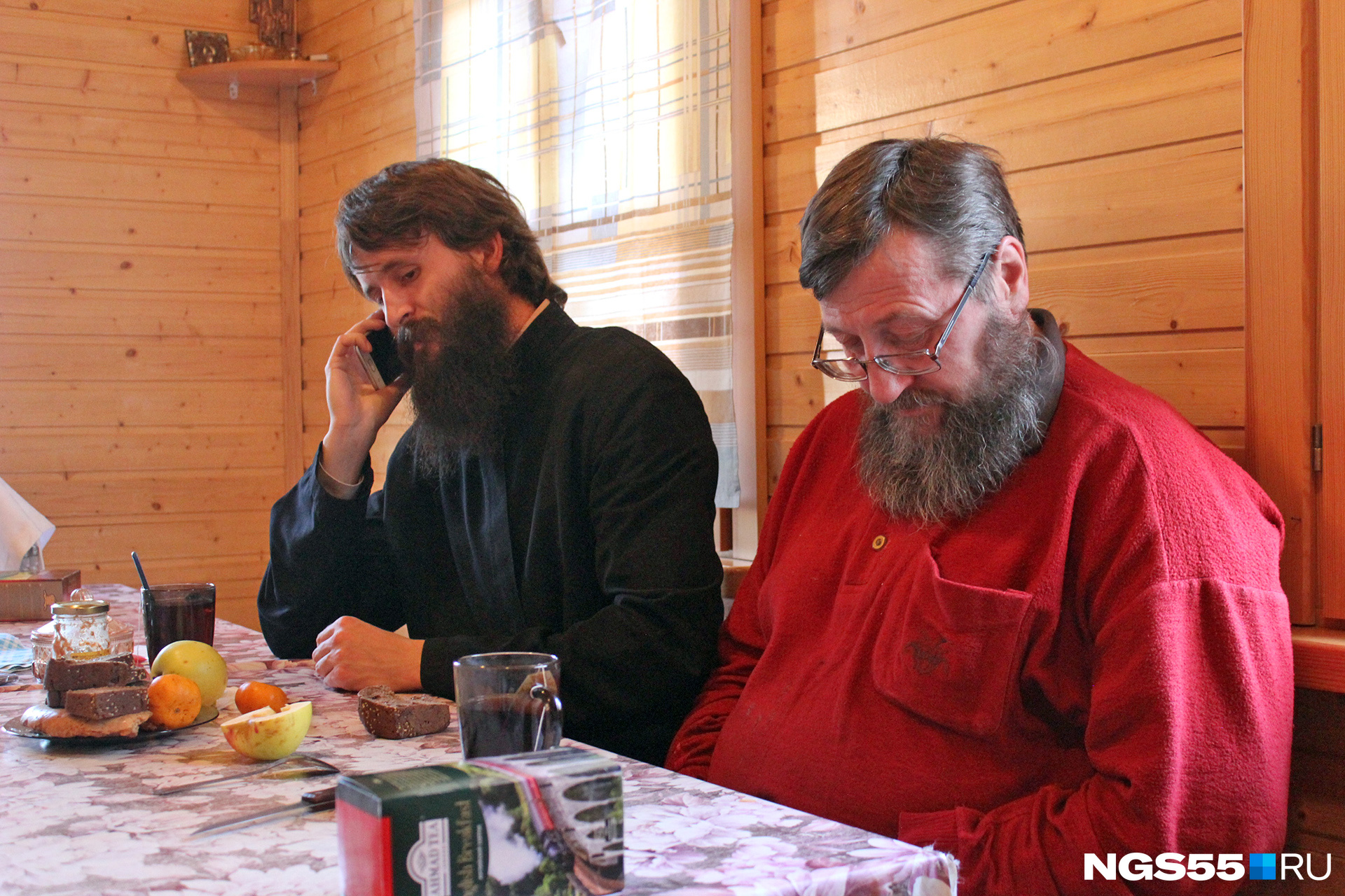 Фото не постановочное: пока отец Пётр отвечает на звонок, Иван проверяет сообщения на телефоне