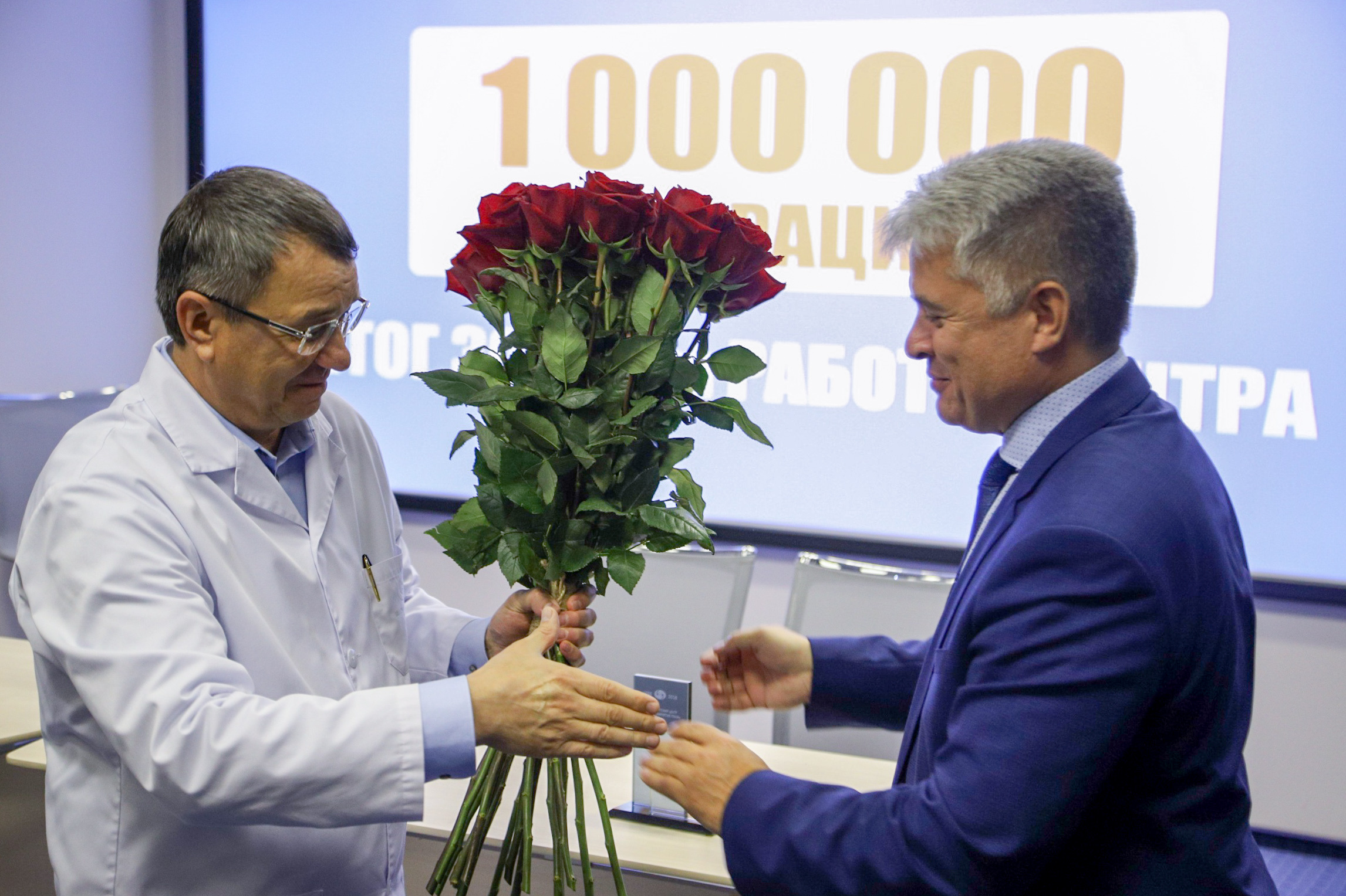 Директор ТФОМС Свердловской области Валерий Шелякин вручает Олегу Шиловских и клинике памятную награду