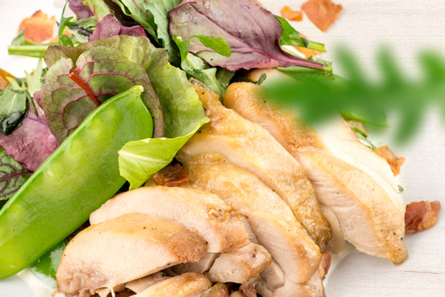 Салат с теплым печеным цыпленком и молодым горошком дополнен ароматными белыми грибами и свежей рукколой с миксом салата.