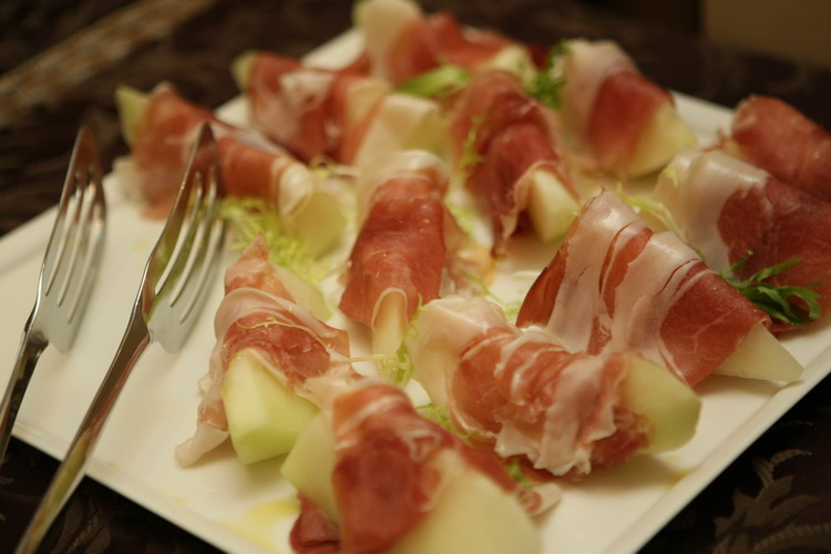 …блюдо «Прошутто с дыней» — дольки дыни, обернутые в кусочки сыровяленного свиного окорока.