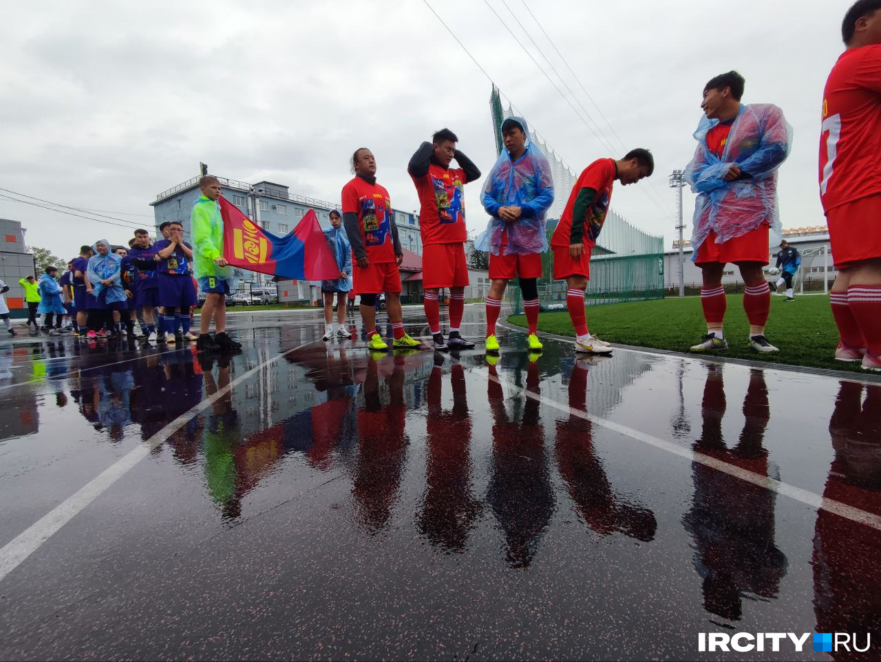 Футболисты пытаются укрыться от дождя