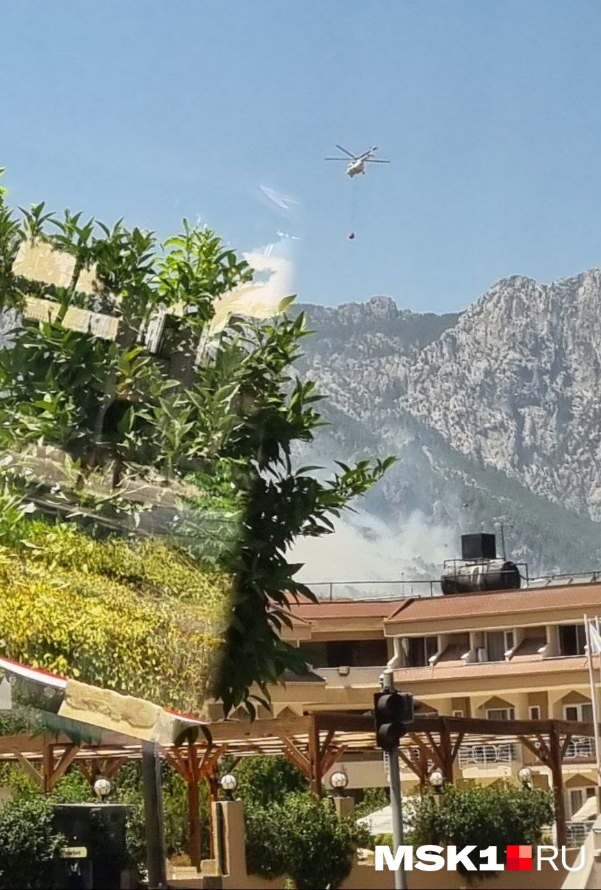 Из отеля туристка видит горы и кружащие пожарные вертолеты