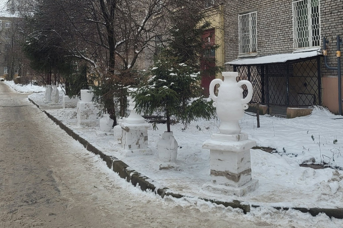 Петербургский снежный скульптор работает над Смольным собором. Посмотрите на белоснежные вазы