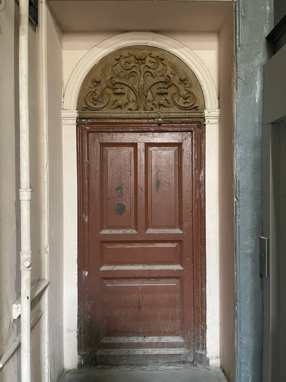 Над дверьми в квартиры сохранилась историческая лепнина
