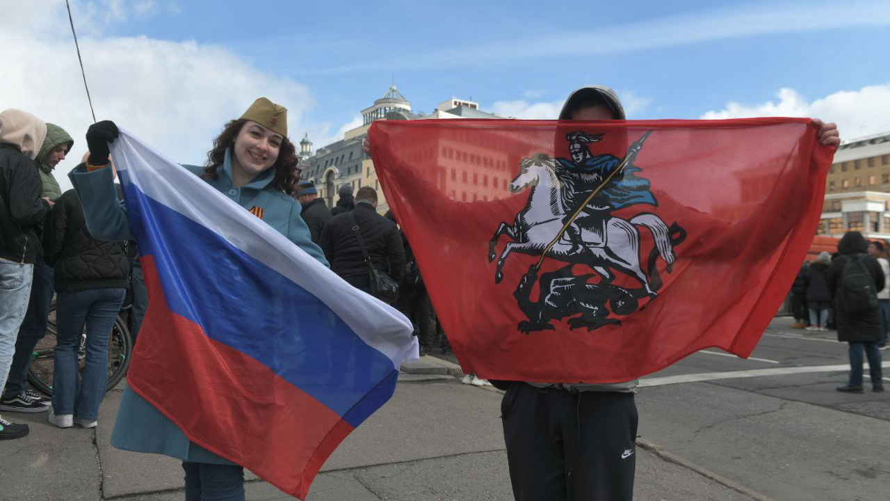 С улыбками и зонтиками: как москвичи и гости столицы смотрят парад Победы