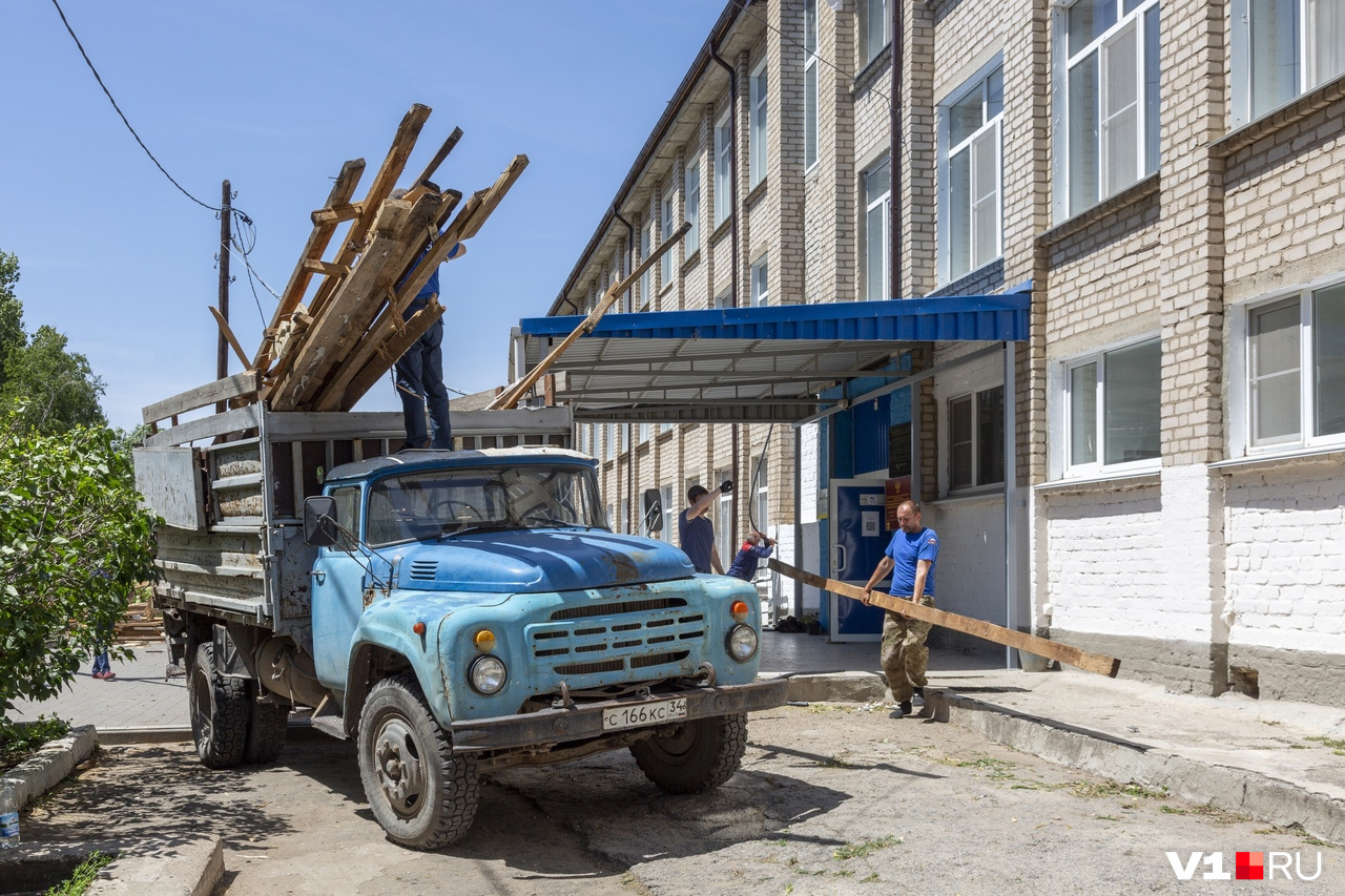 Разрушенные фрагменты кровли собирают в грузовике Разрушенные фрагменты кровли собирают в грузовике