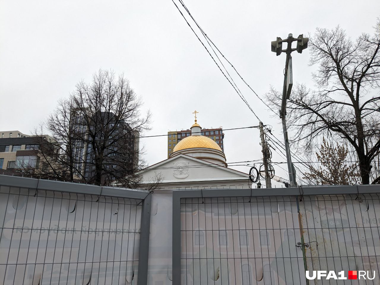 Спасский храм из-за ограждения выглядит крайне антиутопично