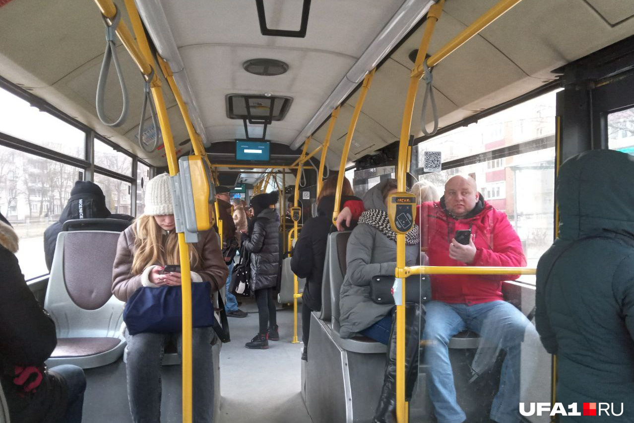 Сочлененный автобус изнутри, на переднем плане видны устройства для оплаты: слева — для билетов, справа — для проездных и карточек