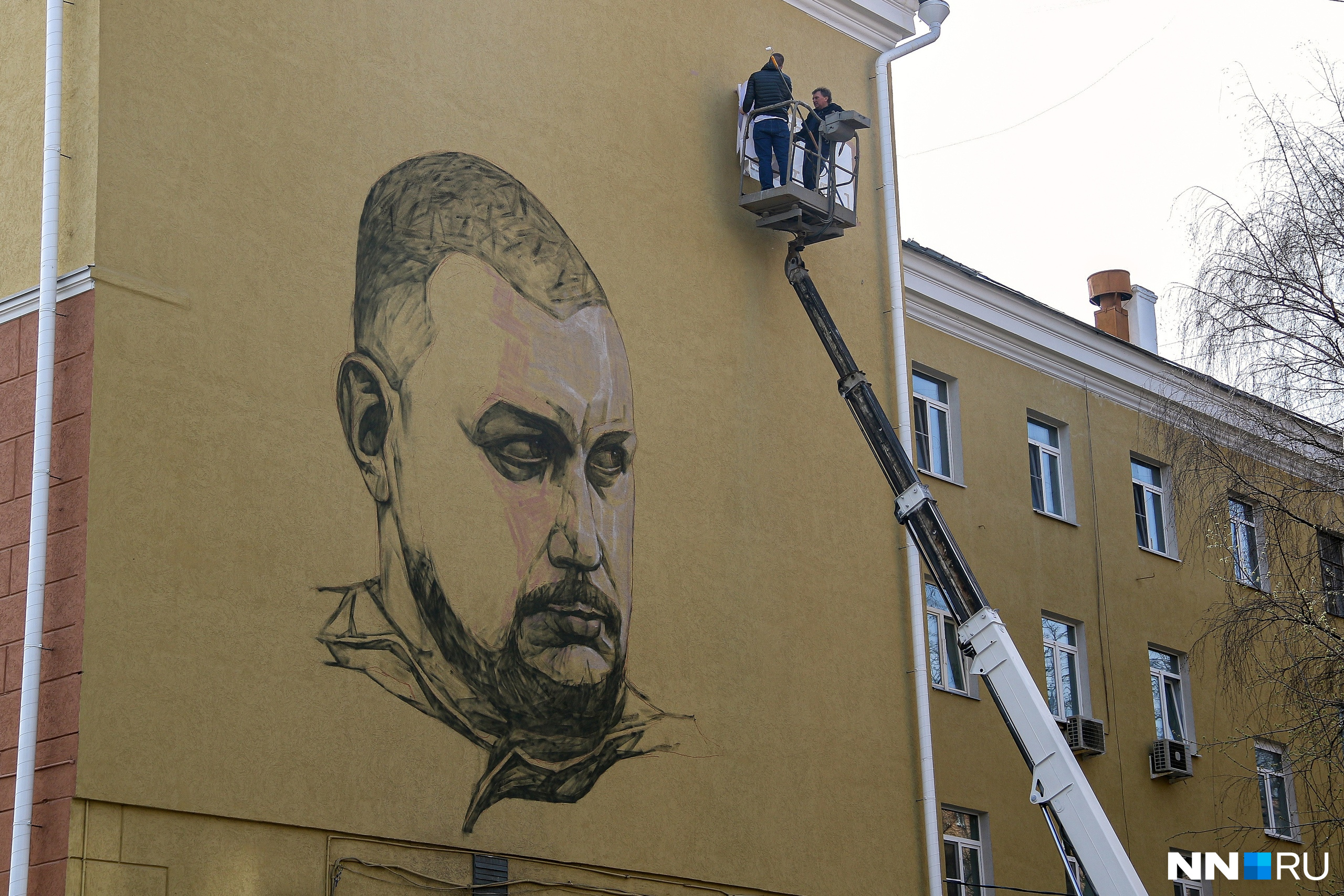 Негр вешает на стену портрет чапаева