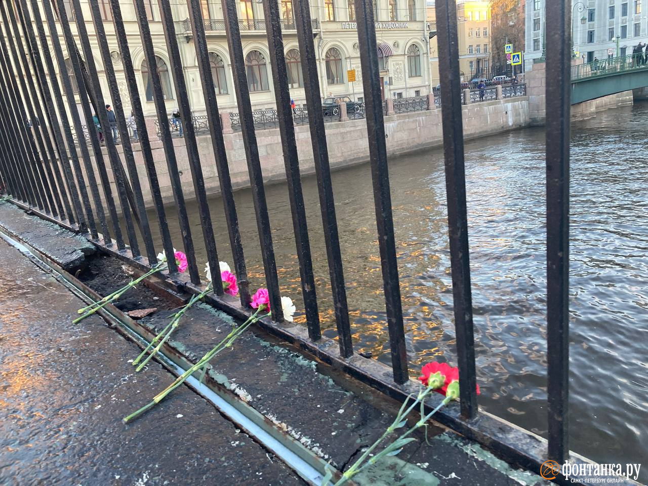 Временное ограждение на Поцелуевом мосту превратилось в народный мемориал. Люди несут туда цветы