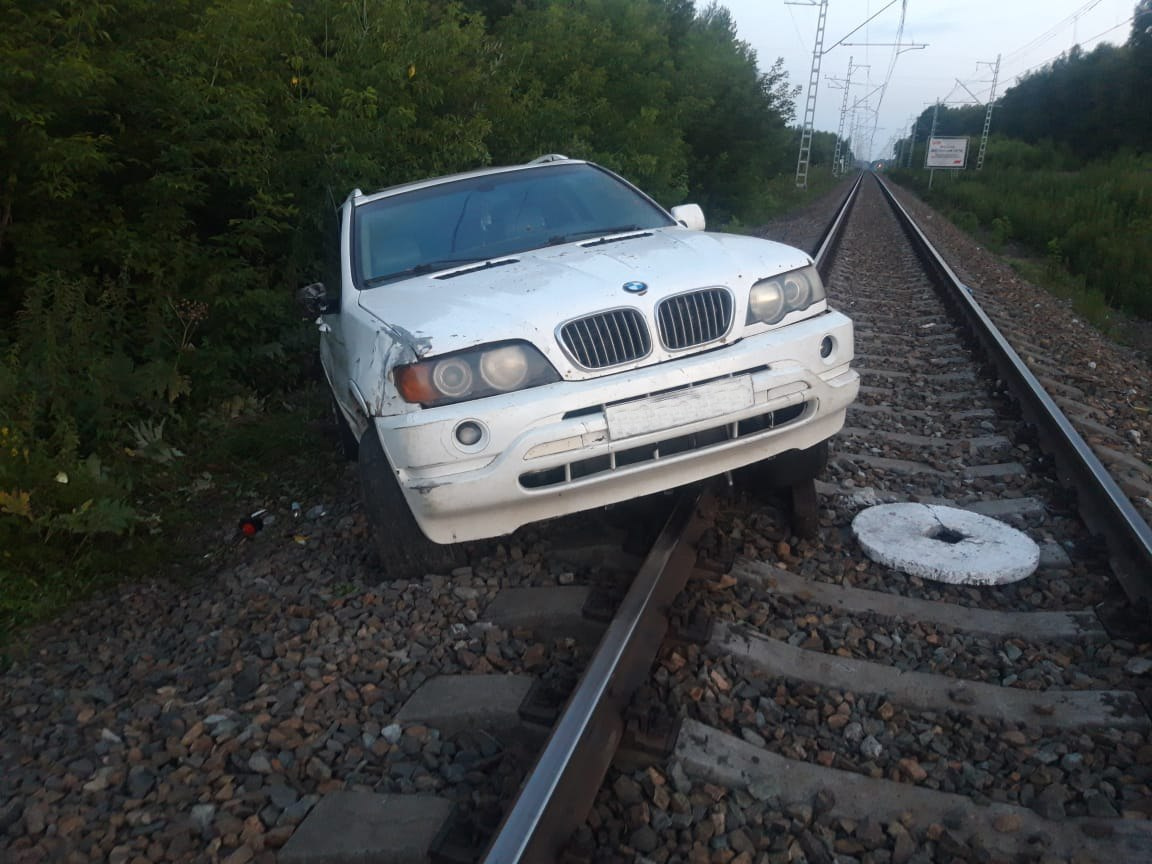 Водитель бросил застрявший BMW X5 на железнодорожных путях под Новосибирском — его ищет полиция