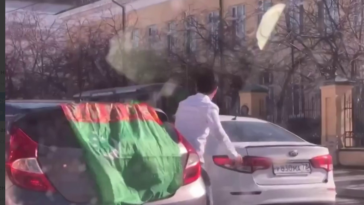 Мужчина сплясал в центре Тюмени прямо посреди автомобильной дороги на фоне флага Туркменистана
