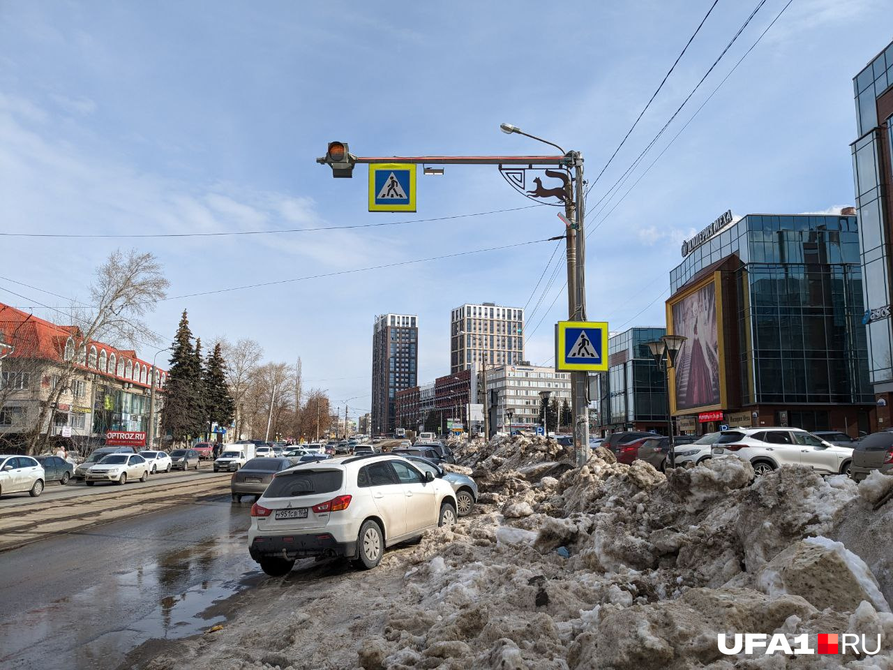 Машины паркуются на горочке из оставшегося снега