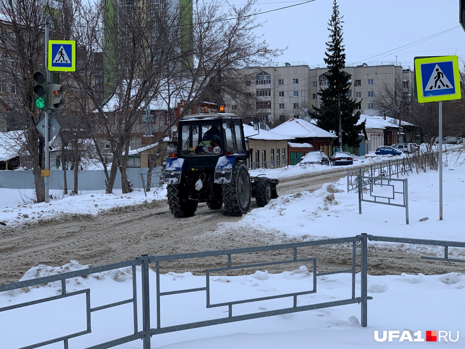 Грустный трактор проехал по заснеженной дороге