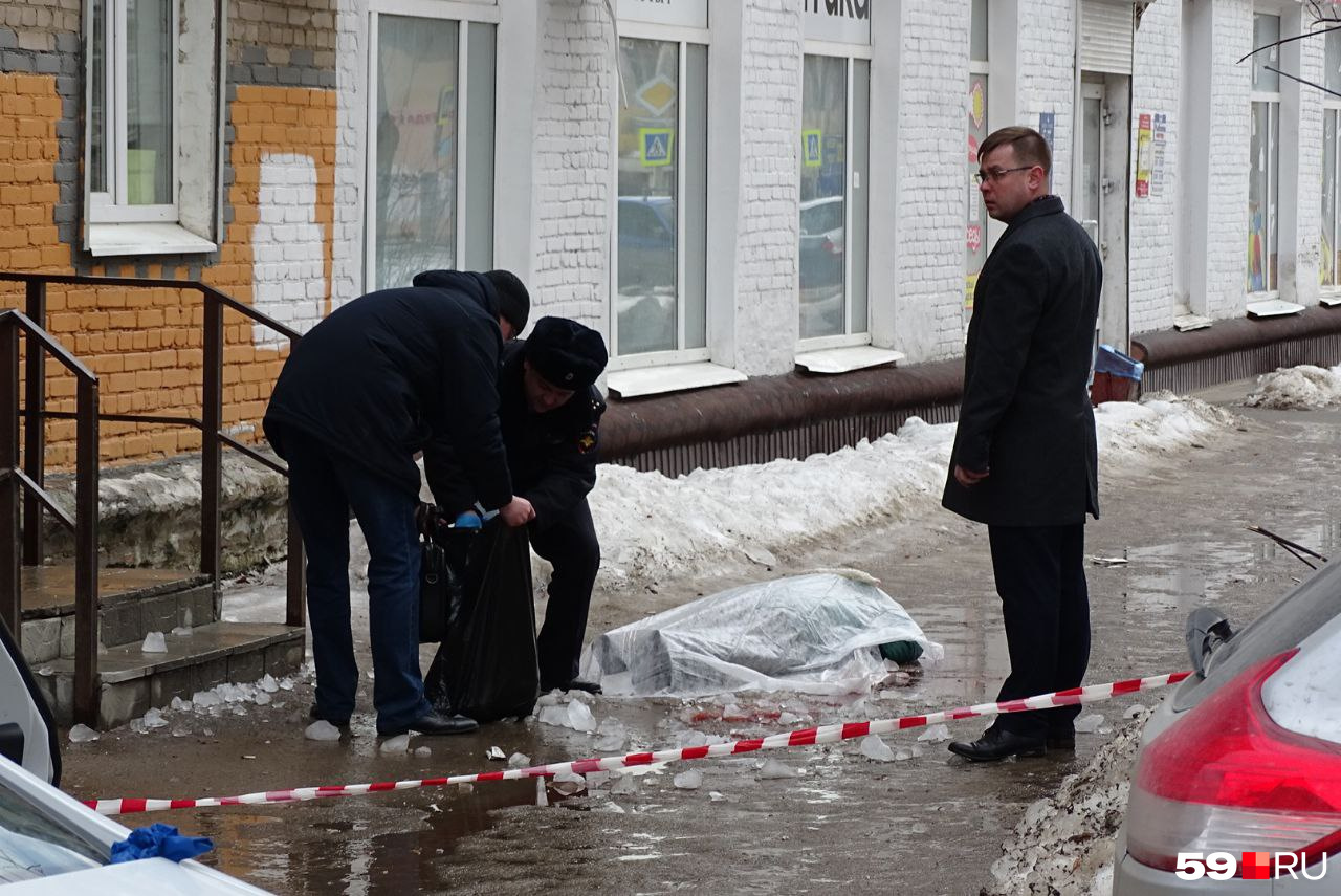 Следователи собирают куски льда, упавшего на женщину, в пакеты