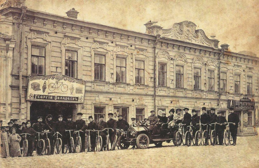 Таким дом Бахарева выглядит на фото 1915 года. Колонна велосипедистов и автомобиль Darracq