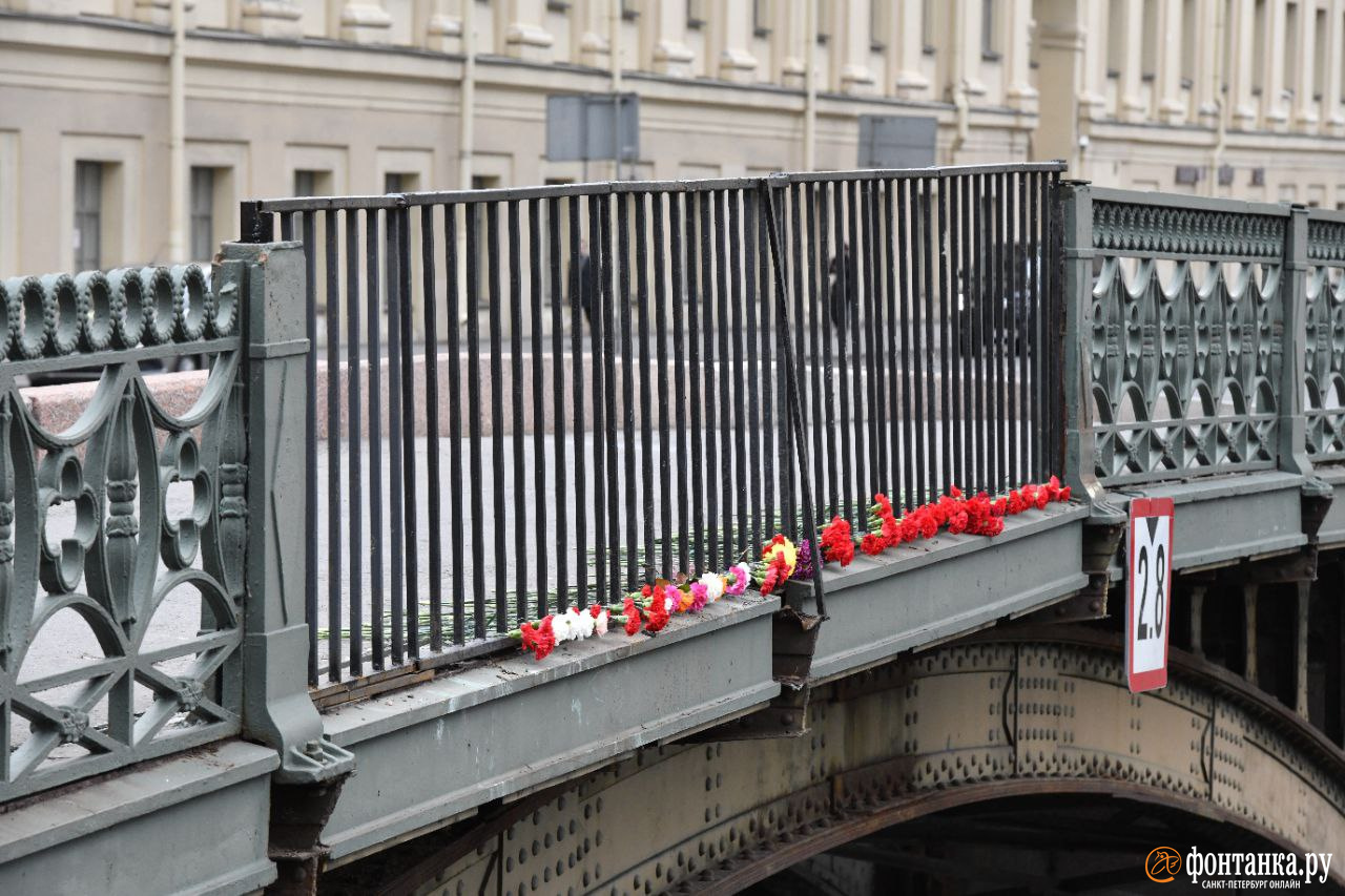 Люди продолжают нести цветы на Поцелуев мост после трагедии с автобусом