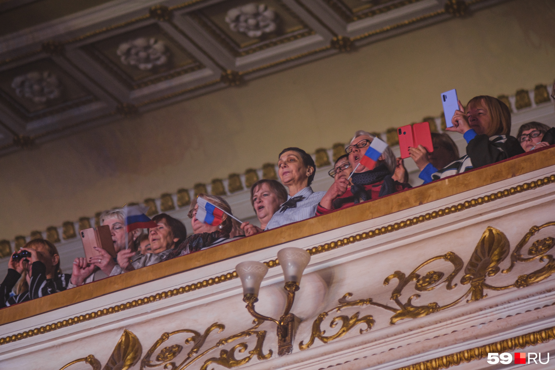 Зрители на балконе тоже с флажками. Расстояние их не пугает — они всё равно снимают на телефон выступление Ярослава