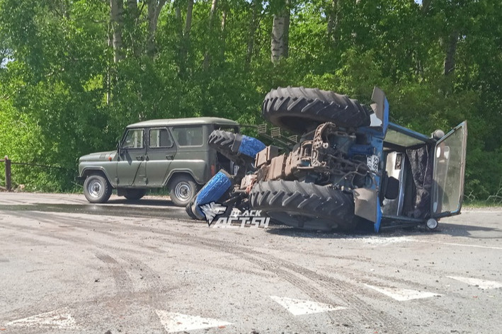 Под Новосибирском на дороге лежит синий трактор — почему он упал