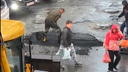 «Клали асфальт в удобное время». В Иркутске заделывали выбоины на дороге прямо в дождь — видео