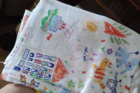 Пеленки с принтом в виде детских рисунков входят в комплект