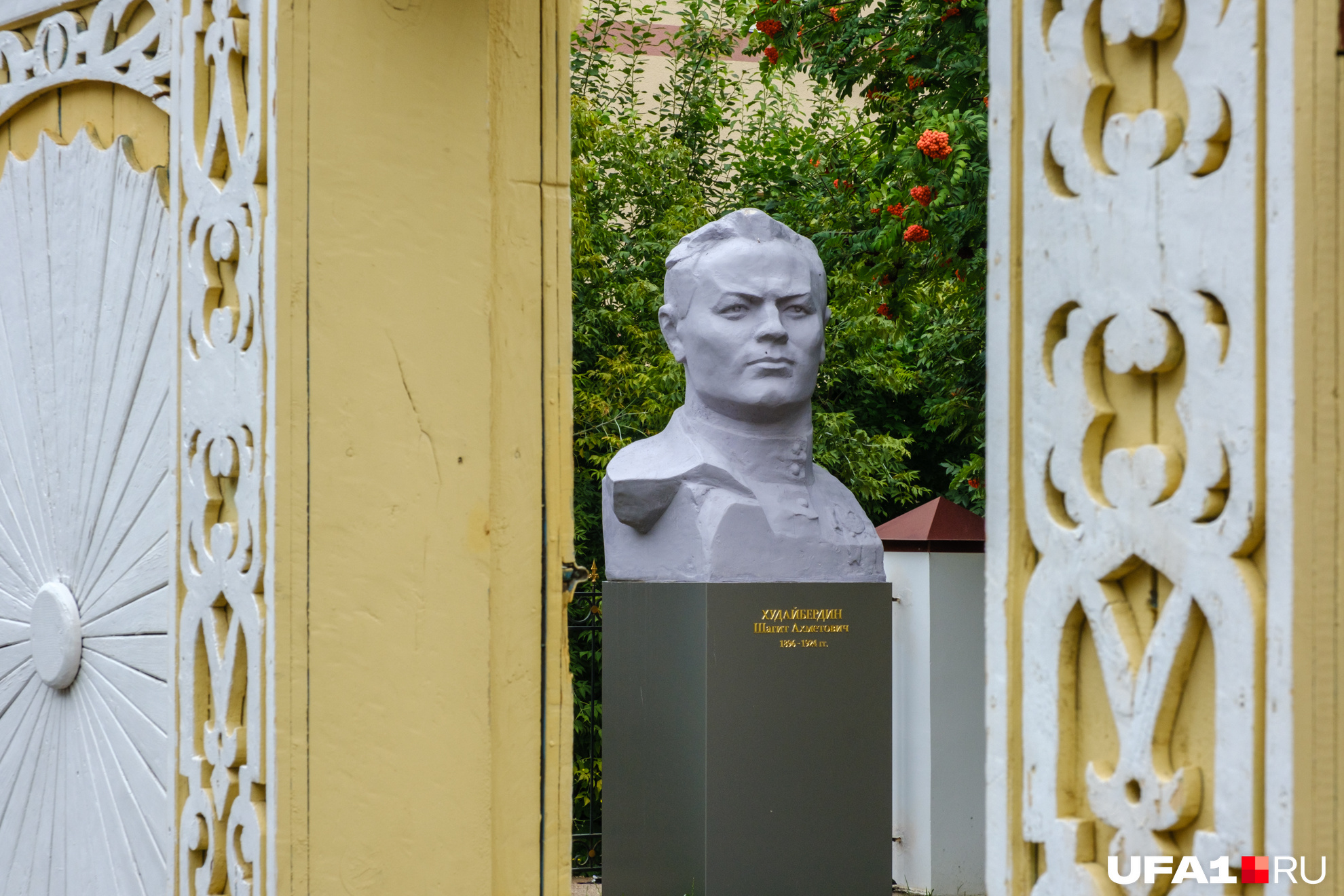 Сам Худайбердин смотрит на всех со двора дома