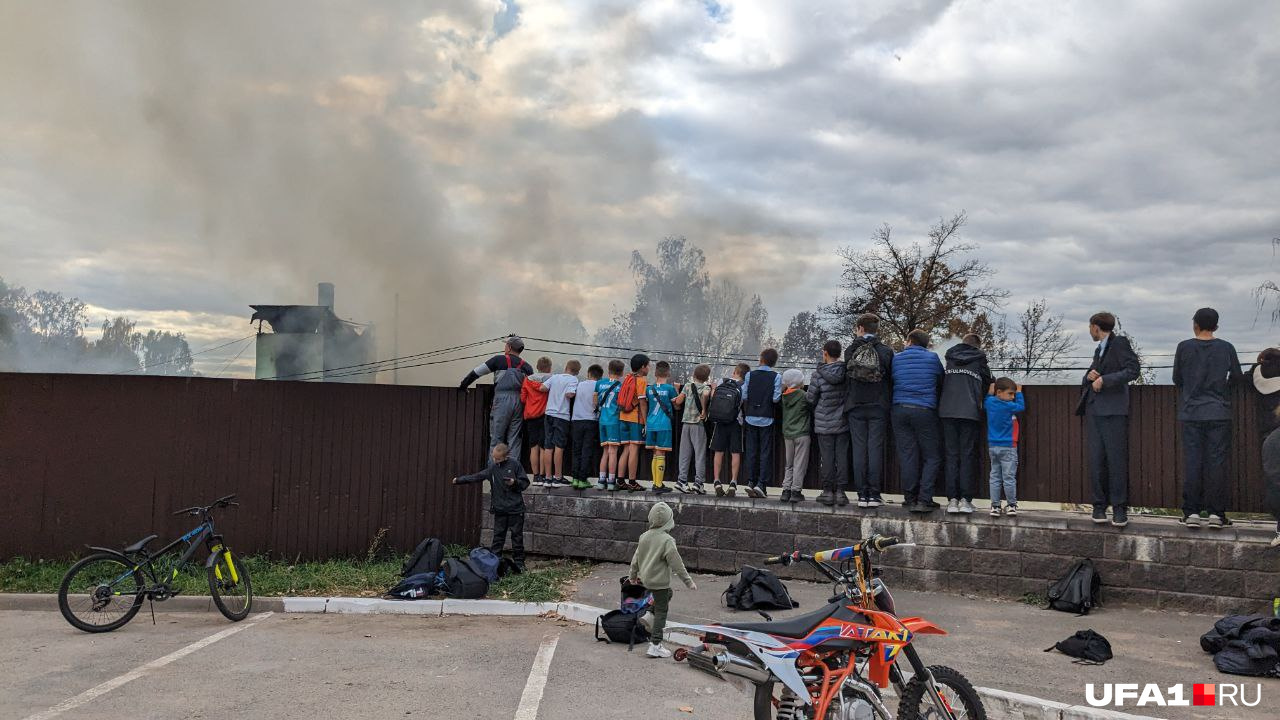 Дети следили за пожаром, выглядывая поверх забора