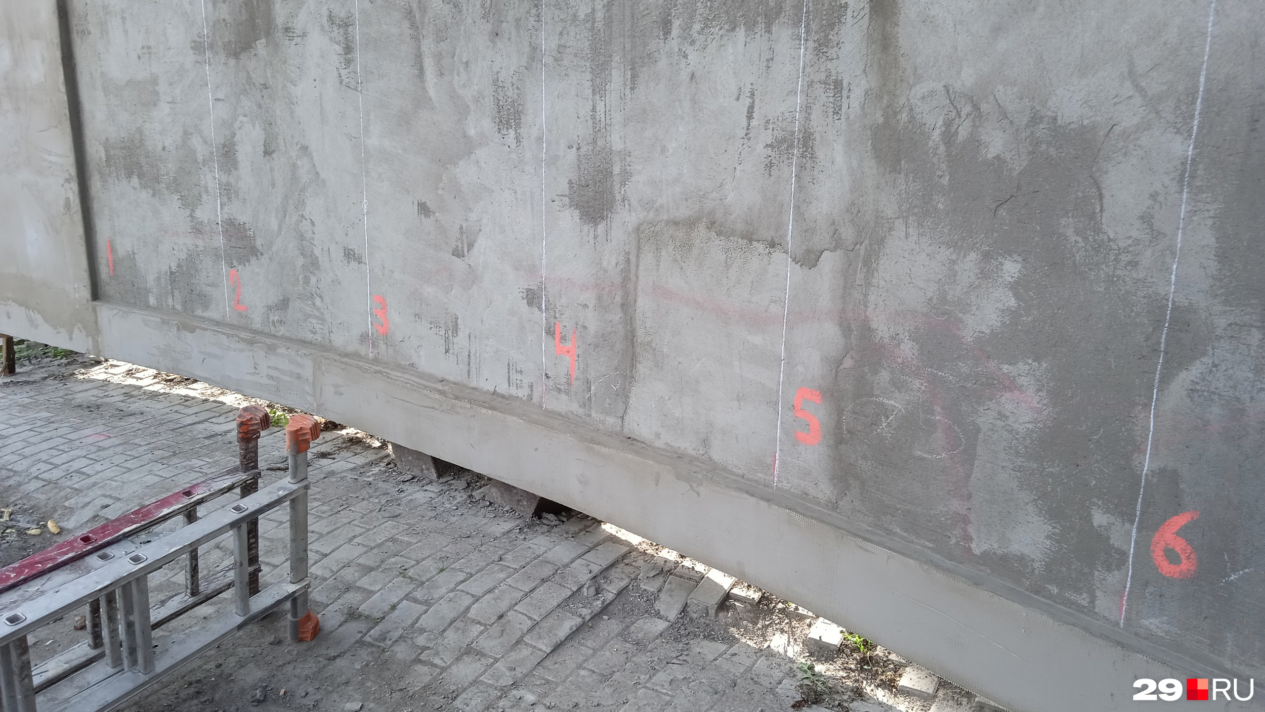 На бетонной стене расчертили места для отдельных блоков