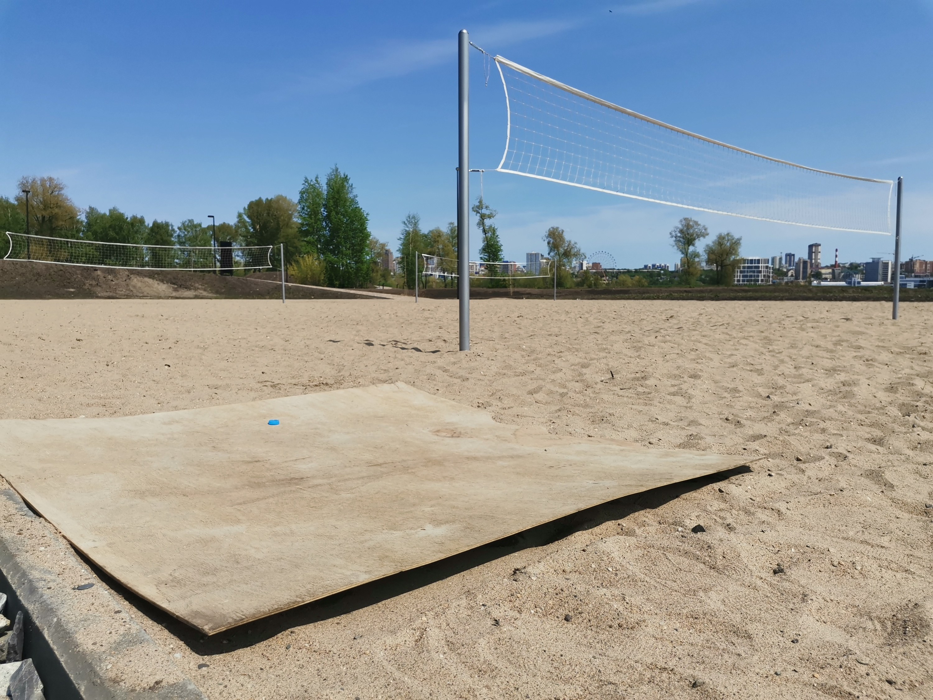 Любители поиграть в волейбол на песке сами принесли на площадку лист фанеры, который служит и местом отдыха, и зоной складирования вещей