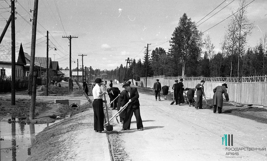 В 1960-е здесь еще не сделали тротуар, а столбы и забор парка имени Чехова (он справа) были деревянными. В кадре — весенний субботник В 1960-е здесь еще не сделали тротуар, а столбы и забор парка имени Чехова (он справа) были деревянными. В кадре — весенний субботник