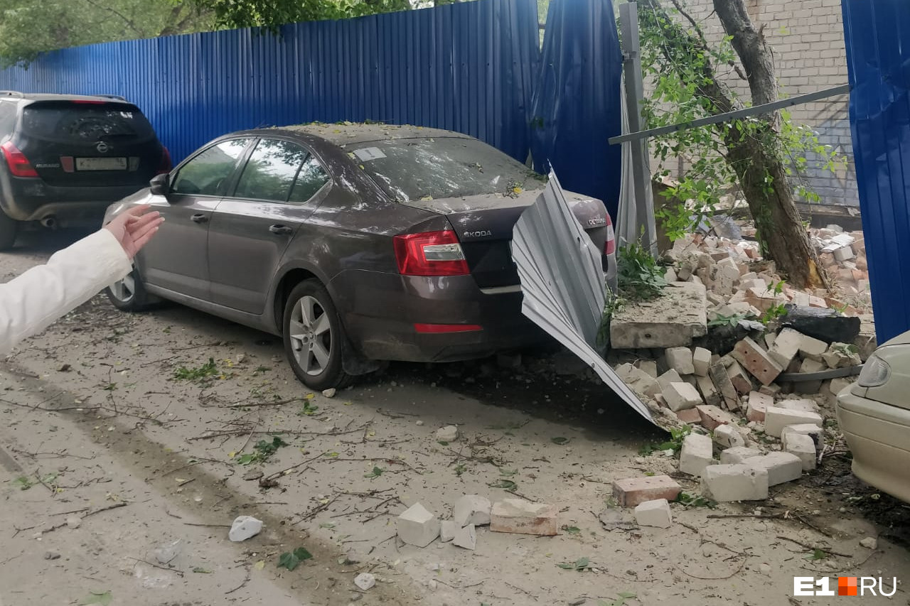 В центре Екатеринбурга, где сносят старый офисник, на легковушку рухнул забор и строительный мусор